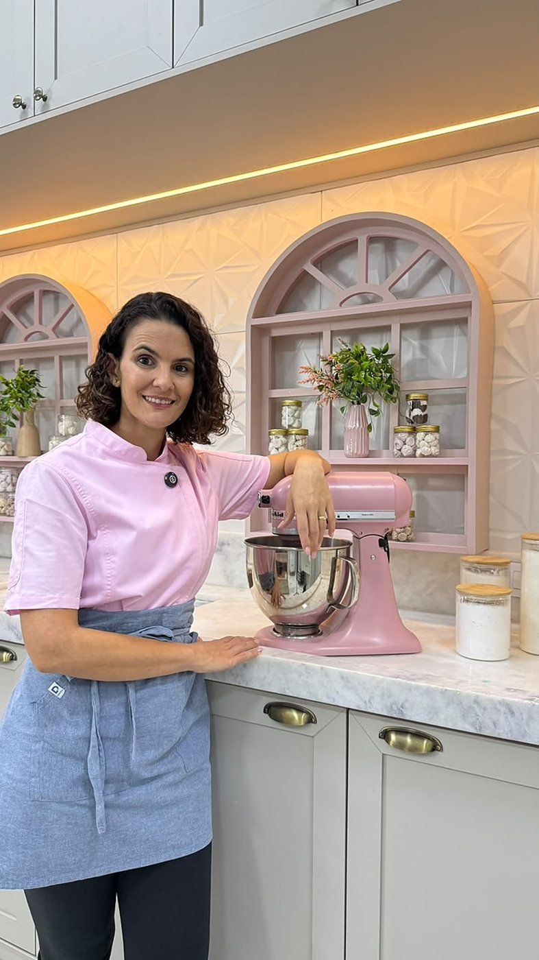 Camila Notário na cozinha, segurando um tubo cheio de suspiros